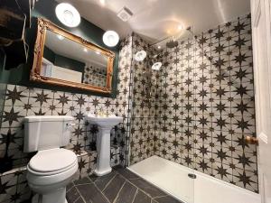 a bathroom with a toilet and a mirror and a tub at Blue Anchor House - Seaview, Hot Tub Apartments in Blue Anchor