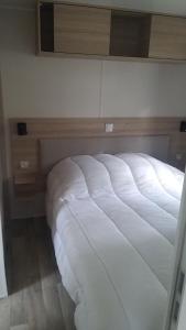 a large white bed sitting in a room at Amira 6 personnes in Saint-Jean-de-Monts