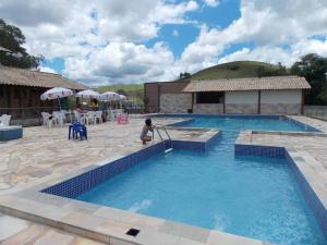 a large swimming pool with a child standing in front of it at Espaço Smidt in Santa Branca