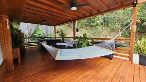 a hammock on a porch with a table and chairs at Palm's Luxury Suite with Private Jacuzzi in Aguada