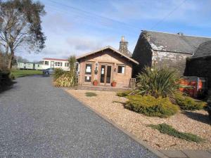 a small house with a driveway in front of it at Castlewigg holiday park Whithorn 2 bed caravan in Newton Stewart