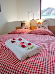 a towel with roses on it sitting on a bed at Cologne Country Lodge in Cologne