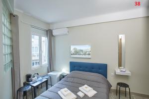 ein Schlafzimmer mit einem blauen Bett und einem Fenster in der Unterkunft ATHENS COMMERCIAL in Athen