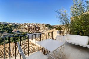 a balcony with a table and chairs and a view of the city at Dimora Bonafede Ibla Design Rooms in Ragusa