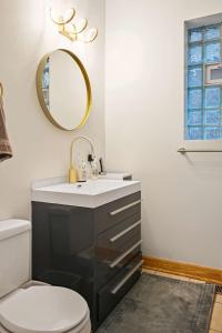 a bathroom with a sink and a toilet and a mirror at 2 Bed Apt w/ Office, Free Parking, Near Wrigley in Chicago