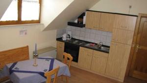een keuken met een tafel, een wastafel en een fornuis bij Ferienhof Christmann in Mossautal