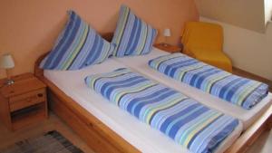 Una cama con almohadas de rayas azules y amarillas. en Ferienhof Christmann, en Mossautal