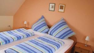 a bedroom with two beds with blue and white pillows at Ferienhof Christmann in Mossautal