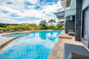 a swimming pool with chairs and a building at Rain Tree Condominium in Chiang Mai