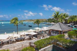a view of a beach with tables and umbrellas at Le Barthélemy Hotel & Spa in Gustavia