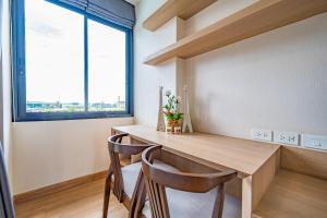 een eetkamer met een tafel en 2 stoelen bij Rain Tree Condominium in Chiang Mai