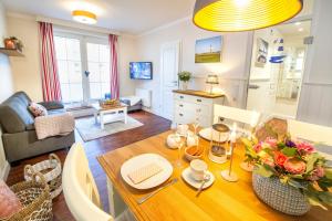 een keuken en een woonkamer met een houten tafel met bloemen erop bij Villa Marina - Weitblick aufs Meer in Wangerooge