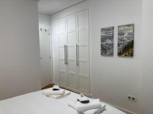 um quarto branco com duas toalhas numa cama em Angliru 1 Suite em Castandiello