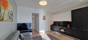 a living room with a couch and a flat screen tv at Sea & City view Home near Nature in Helsinki