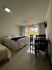 ディアマンティーナにあるHOTEL ESTAÇÃOのベッドルーム1室(ベッド1台、テーブル、椅子付)