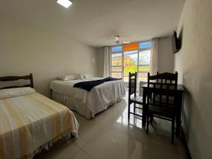 ディアマンティーナにあるHOTEL ESTAÇÃOのベッドルーム1室(ベッド2台、デスク、窓付)