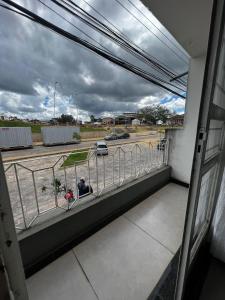 a person sitting on a balcony looking out at a parking lot at HOTEL ESTAÇÃO in Diamantina