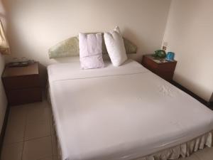 a bed with white sheets and pillows in a room at Residence Inn Pattaya in Pattaya Central