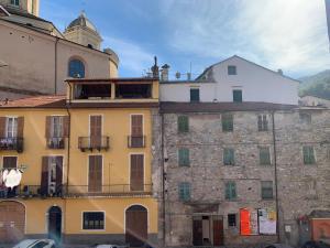 un vieux bâtiment et un bâtiment avec une tour de l'horloge dans l'établissement Albergo Dell'Angelo, à Pieve di Teco