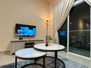 a living room with a table and a tv at Twin Galaxy city view 2 Bedroom with balcony in Johor Bahru