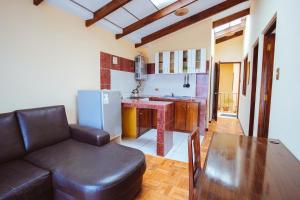 sala de estar con sofá, mesa y cocina en La Maison Martinet en Uyuni