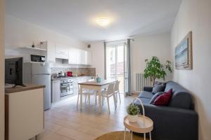 ein Wohnzimmer und eine Küche mit einem Sofa und einem Tisch in der Unterkunft Il Faro appartamenti in San Vincenzo