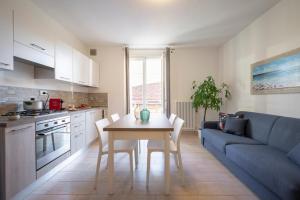 una cucina e un soggiorno con tavolo e divano blu di Il Faro appartamenti a San Vincenzo