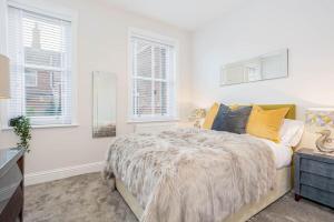 ein Schlafzimmer mit einem Bett und zwei Fenstern in der Unterkunft Coppergate Mews Grimsby No.3 - 2 bed, 2 bath, ground floor apartment in Grimsby