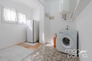 a white laundry room with a washing machine in it at Villa Elvira by MarCalma in Les tres Cales