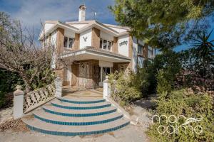 a house with blue stairs in front of it at Villa Elvira by MarCalma in Les tres Cales