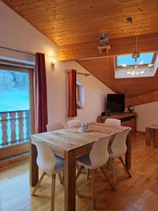 ein Esszimmer mit einem Holztisch und Stühlen in der Unterkunft Appartement tout confort montagne et lac Léman in Thollon
