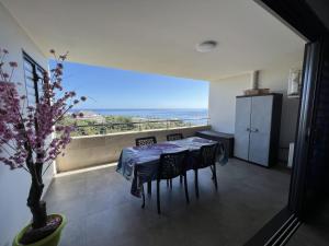 a dining room with a table and a view of the ocean at Charmant F2 à SkyNui, piscine de 25m et vue mer in Papeete