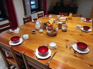 un tavolo in legno con piatti rossi e una ciotola di cibo di Chez Pierrot Chambres d'hôtes B&B a Vallouise
