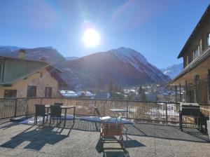 a patio with a table and chairs and a mountain at Chez Pierrot Chambres d'hôtes B&B in Vallouise