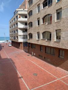 a brick building on a sidewalk next to the beach at Las Canteras 128 in Las Palmas de Gran Canaria