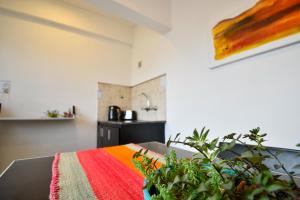 Cette chambre comprend une table et une couverture colorée. dans l'établissement Apartamentos Ref, à Salta