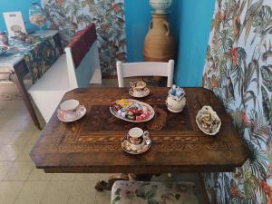 un tavolo di legno con tazze e piatti di cibo sopra di B&B Leopardi a Montefiore dellʼAso