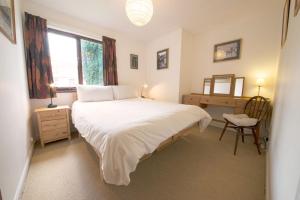 a bedroom with a bed and a desk and a window at Beck Yeat Cottage Coniston in Coniston