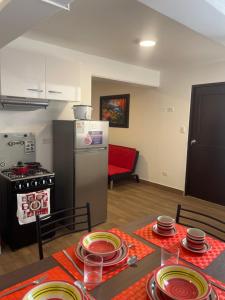 a kitchen with a table with plates and a refrigerator at (21) Depto. nuevo y acogedor en Miraflores in Lima +9 photos