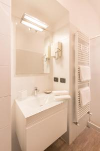 La salle de bains blanche est pourvue d'un lavabo et d'un miroir. dans l'établissement Loppia Bay by Wonderful Italy, à Bellagio