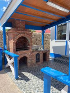 a patio with a brick oven and blue benches at Pensiunea Blue House in Vadu