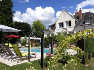 uma casa com piscina e cadeiras e uma casa em Gîtes et Chambres des Coteaux em Sainte-Maure-de-Touraine