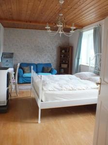 a bedroom with a white bed and a blue couch at Ferienhaus in Unken mit Großer Terrasse in Unken