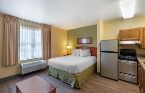 a hotel room with a bed and a refrigerator at Extended Stay America Suites - Norfolk - Virginia Beach in Virginia Beach