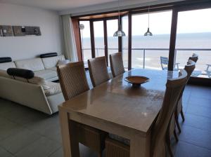 a living room with a table and chairs with a view of the ocean at LUXURY APP, frontal sea View + south terrace + garage in Middelkerke