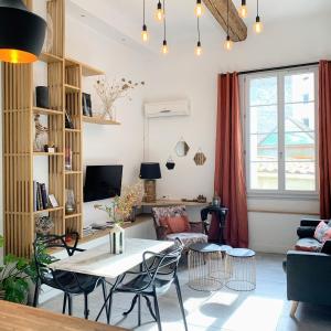 un soggiorno con tavolo e sedie di Home Chic Home - Les Suites de La Comédie a Montpellier