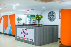 a reception desk in a lobby with a clock on the wall at The View Hotel Restaurant & Sky Lounge in Freetown