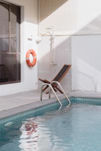 uma piscina com uma cadeira numa casa em Villa Number 4 em Sharjah