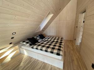 ジェレズナー・ルダにあるHorská chata Belvederの木製の部屋にベッド1台が備わるベッドルーム1室があります。