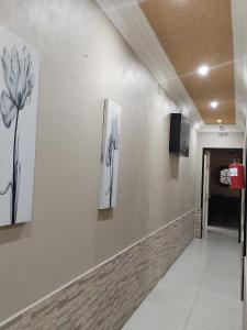 a hallway with three paintings on the wall at Ditsaleng Bed and Breakfast in Vanderbijlpark